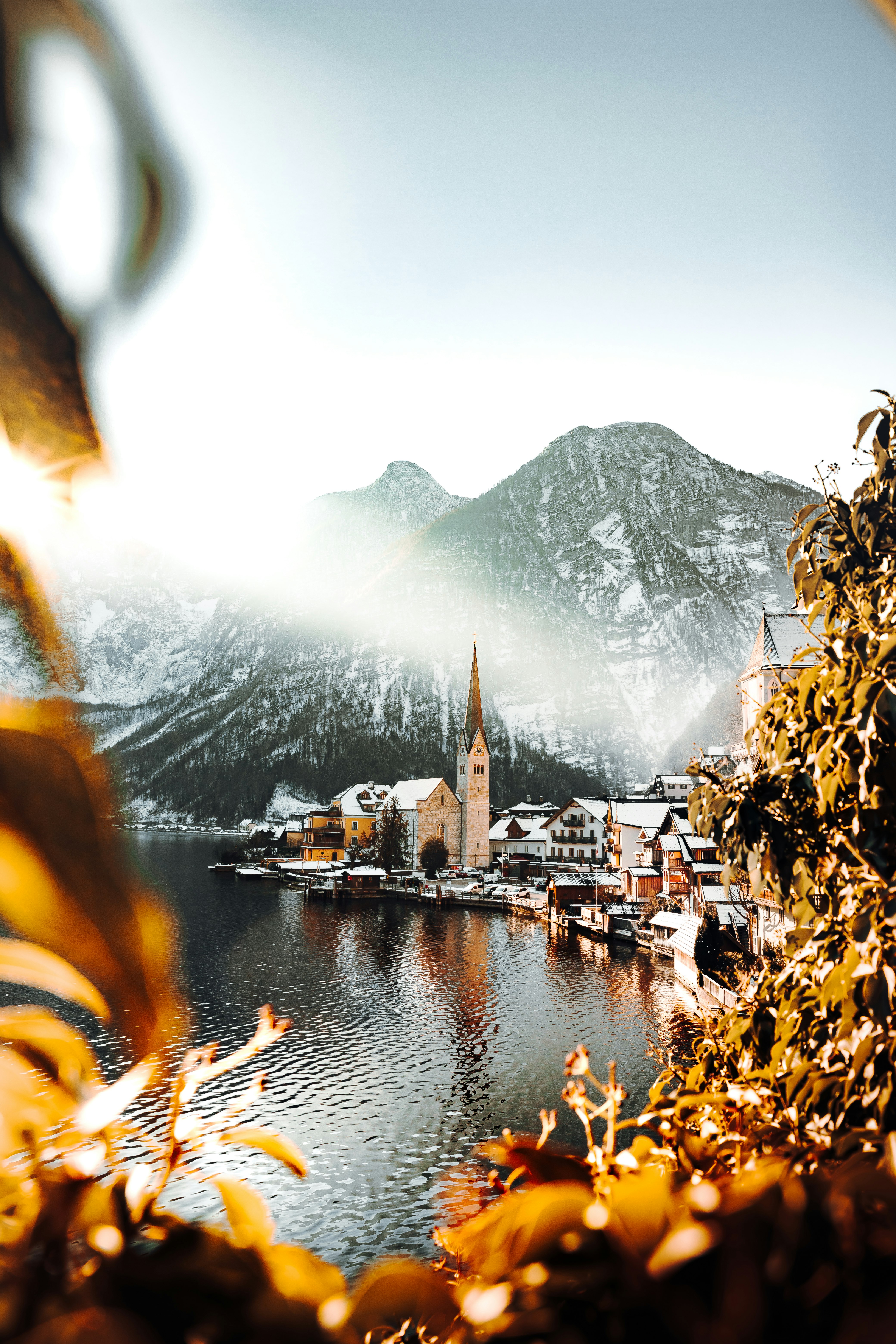 brown and white houses near body of water and mountain during daytime